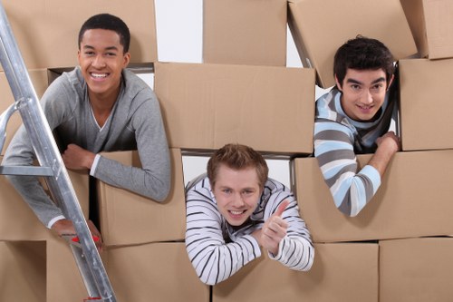 Local moving team navigating a Chiswick street with packed furniture